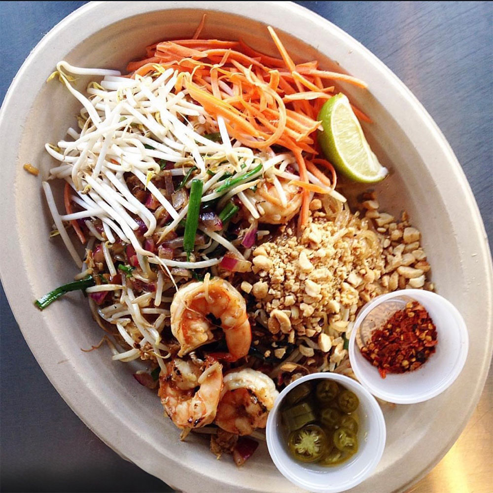 Bowl with shrimp, carrots, bean sprouts, peanuts and lime