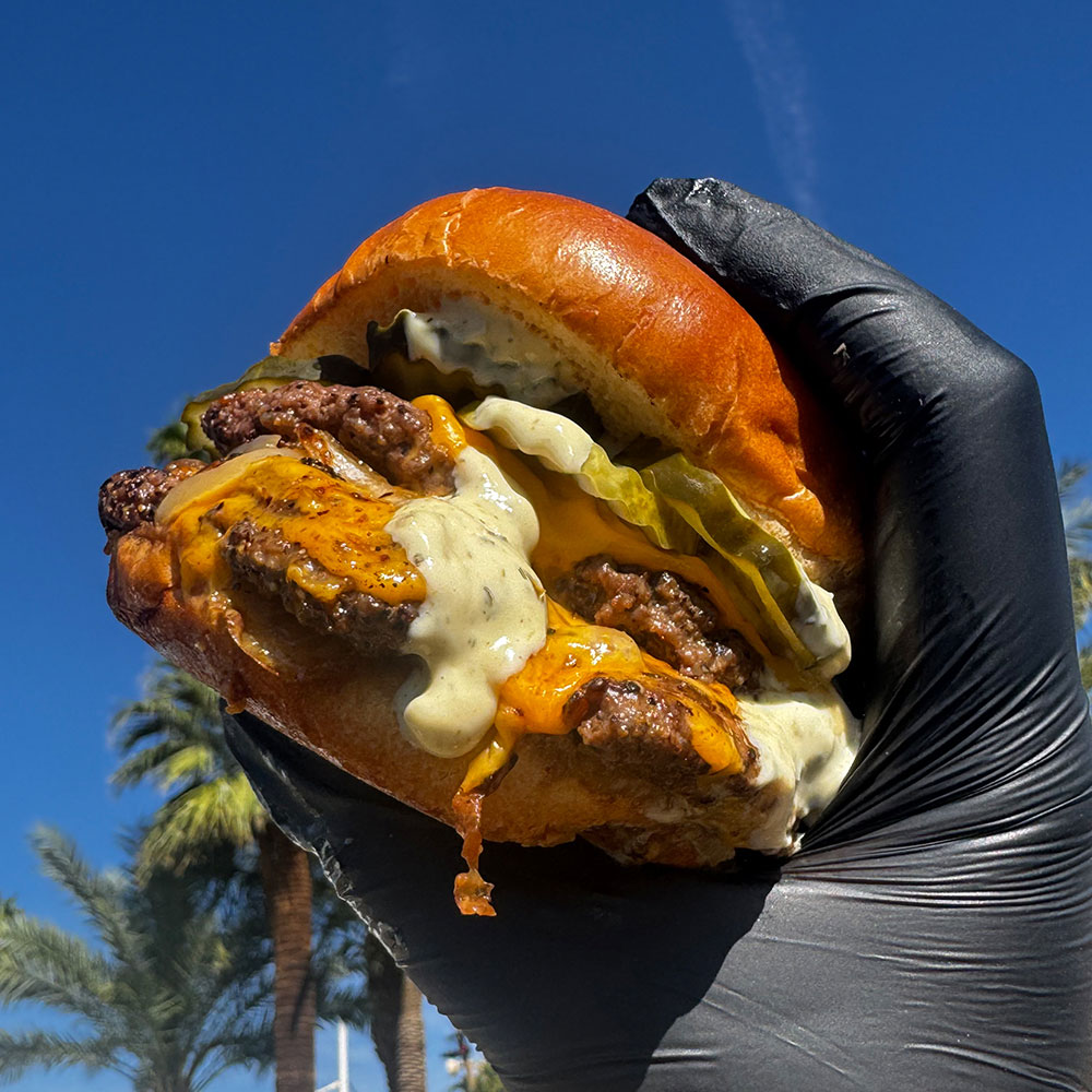 Cheeseburger with blue sky and palm trees in background